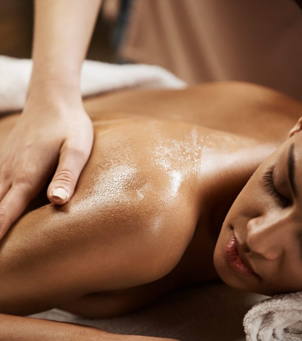 Close up photo of beautiful african girl enjoying massage in spa salon.